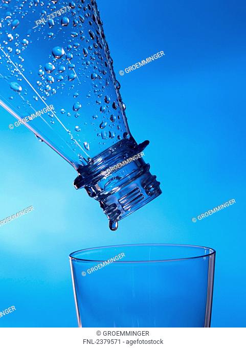 Close-up of water droplets being poured from bottle into glass
