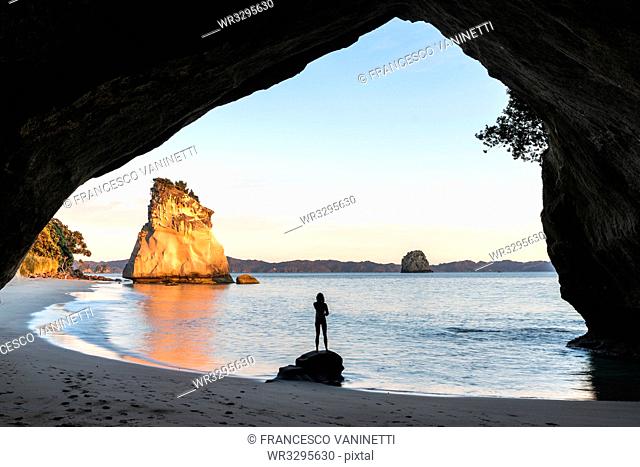 Woman's silhouette at Cathedral Cove, Hahei, Waikato region, North Island, New Zealand, Pacific