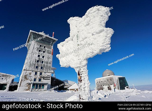 24 January 2023, Saxony-Anhalt, Schierke: Thick ice sheets form on a signpost on the Brocken. Bright sunshine and hardly any wind at temperatures around minus 2...
