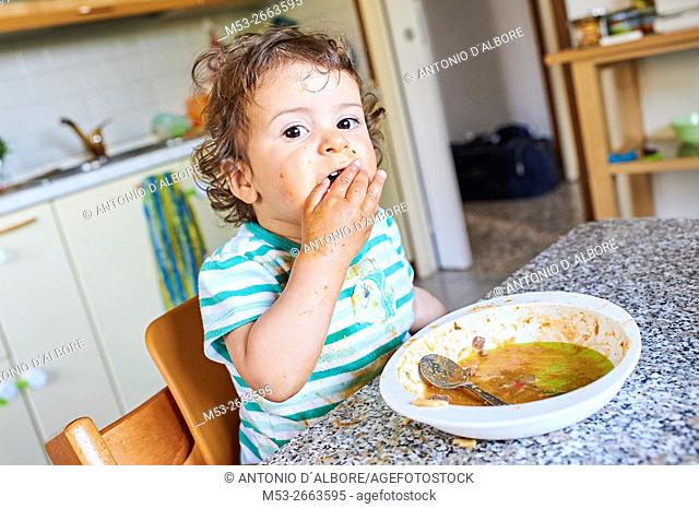A sixteen months old baby girl learning to eat
