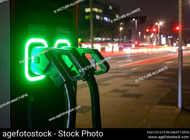 19 December 2023, Lower Saxony, Hanover: Charging cables light up green at a fast charging station for electric cars. After the sudden end of the purchase...