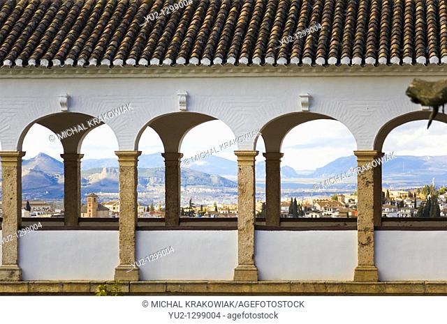 Detail of palace in Generalife, Alhambra with panorama of Granada behind columns