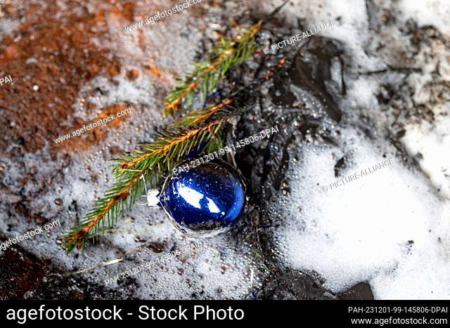 01 December 2023, Berlin: A charred Christmas tree ball lies on the ground during a demonstration of a fire during the Christmas season on the grounds of the...
