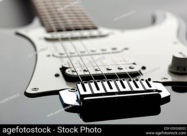 Electric guitar, focus selection on strings, black top on background, nobody. Musical instrument, electro sound, electronic music, equipment for stage concert