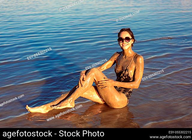A young woman enjoying the natural mineral mud sourced from the dead sea, Israel