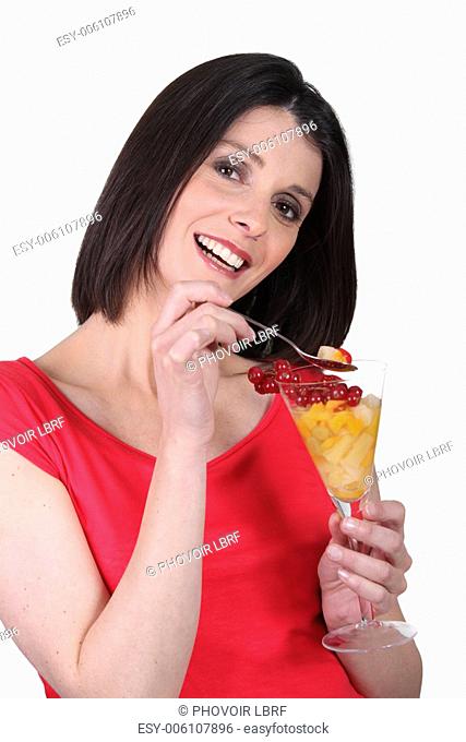 Woman eating fruit cocktail