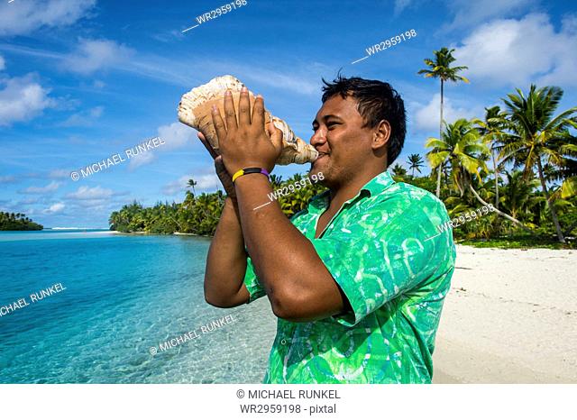 Local man blowing a huge conch, Aitutaki lagoon, Rarotonga and the Cook Islands, South Pacific, Pacific