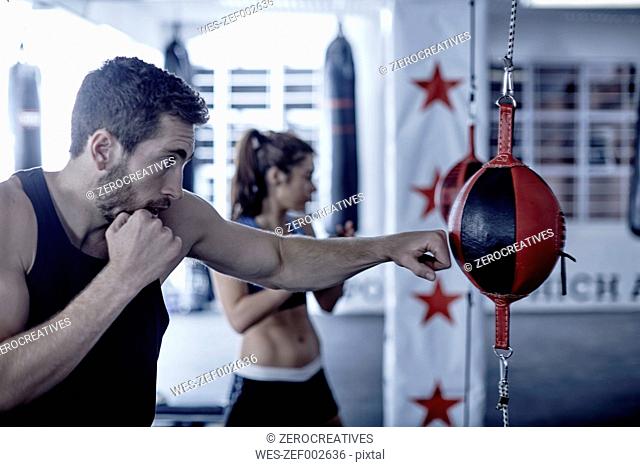 Man and woman exercising with punchingballs