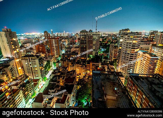 Aerial view of cityscape with residential buildings and office buildings at night