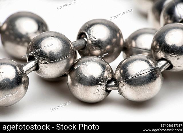 Macro shot of silver metal ball necklace on a white background
