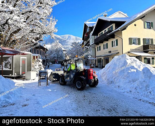 03 December 2023, Bavaria, Garmisch-Partenkirchen: A wheel loader clears snow from a road. An unusually severe onset of winter brought snow