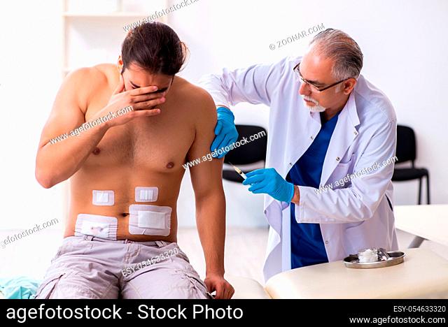 Injured man visiting experienced male doctor