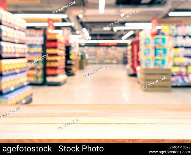 Light wooden board empty table in front of blurred background. Perspective light wood over blur in supermarket - can be used for display or montage your...
