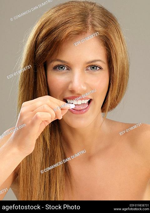 beautiful woman taking a pill smiling