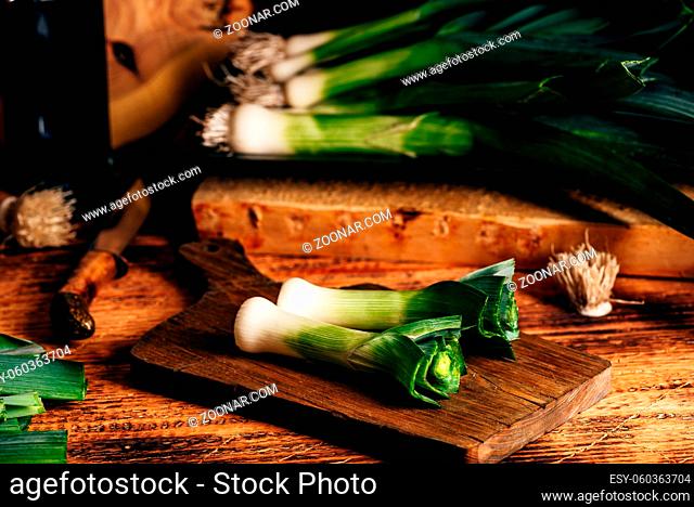 Fresh green leek on wooden cutting board