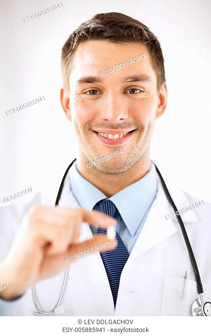 healthcare and medical concept - young male doctor offering pill