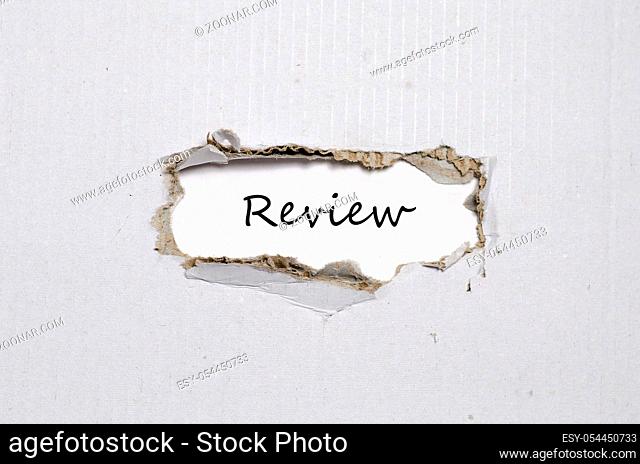 The word review appearing behind torn paper