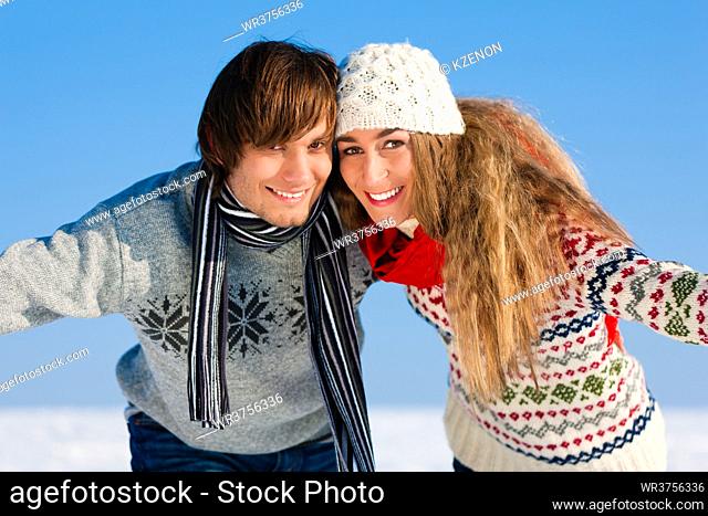 Couple - man and woman - having a winter walk embracing each other