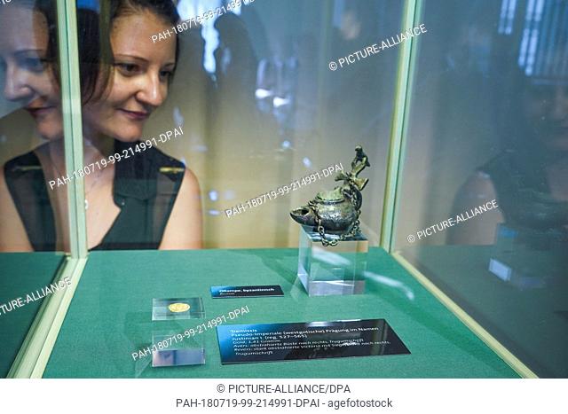 19 July 2018, Germany, Gotha: An oil lamp and a gold coin minted in then-Visigothic Spain on display in Friedenstein Palace during the presentation ""The Lords...