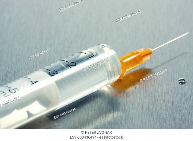 Drop of a liquid on a needle of syringe