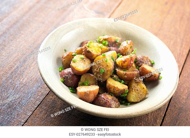 Freshly oven baked baby potatoes with skin on wooden table