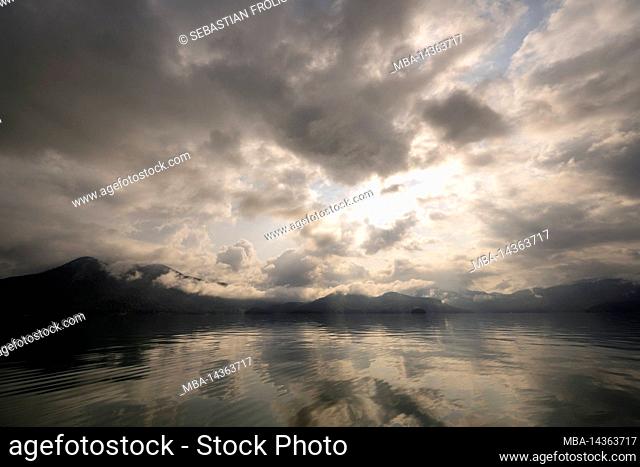 Cloud atmosphere at Walchensee in the backlight. View from Zwergern to the island Sassau and Niedernach