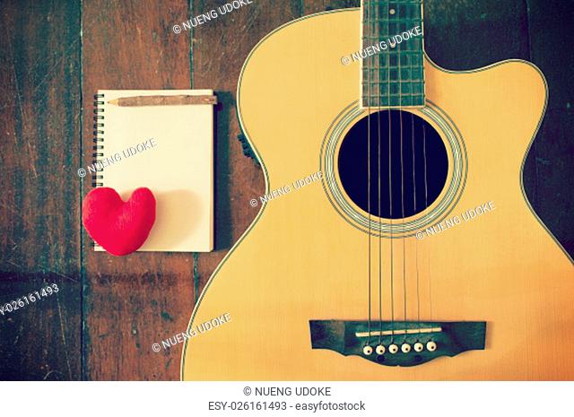 Notebook and wooden pencil with heart on guitar, Writing music filtered effect
