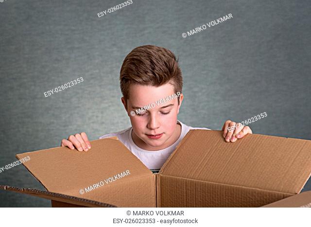 boy is looking in a big cardboard box