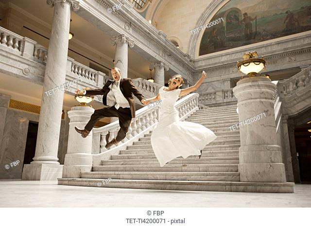 Bride and groom leaping from steps