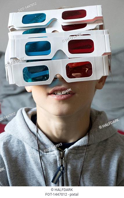 A boy wearing a large amount of 3-D glasses