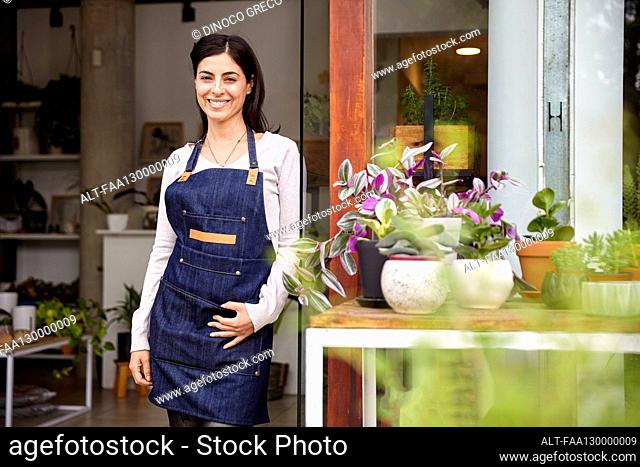 Plant nursery owner standing in store while looking at the camera
