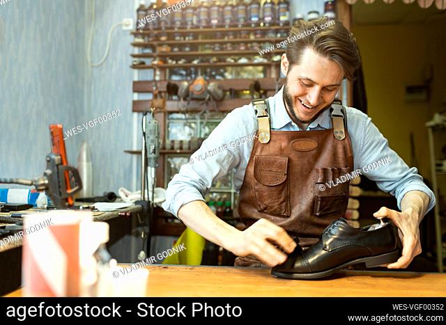 Male shoemaker polishing black shoe at workshop