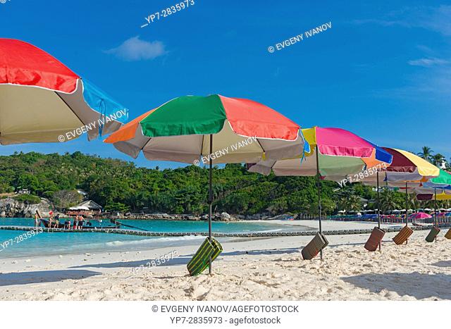 Beach umbrellas waiting for tourists in Raya island, Thailand