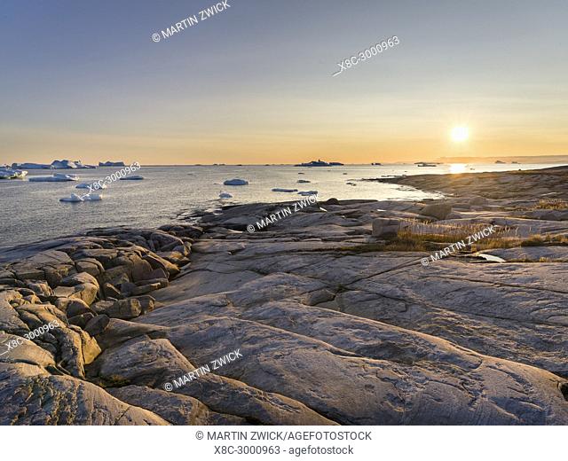 Coastal landscape with Icebergs. The Inuit village Oqaatsut (once called Rodebay) located in the Disko Bay. America, North America, Greenland, Denmark
