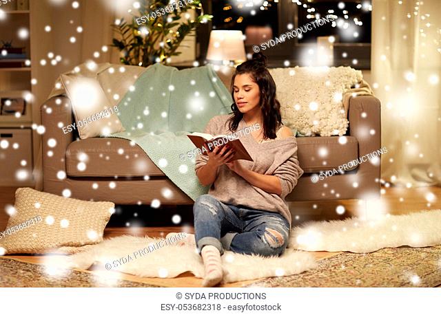 happy young woman reading book at home