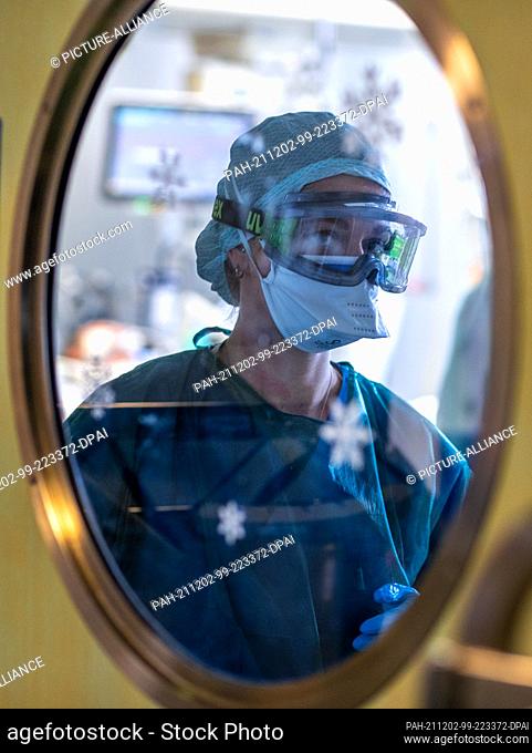 30 November 2021, Mecklenburg-Western Pomerania, Rostock: Nurse Anne-Marie Kalinowski working in protective equipment in one of the treatment rooms of the...