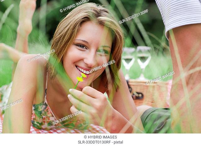 Woman with flower on picnic blanket