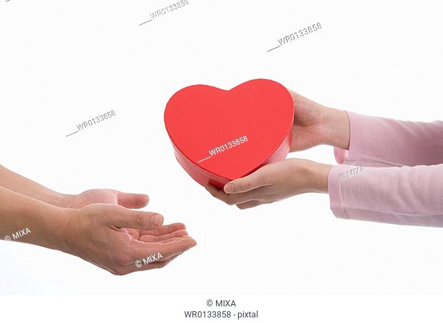 Woman giving man heart-shaped box