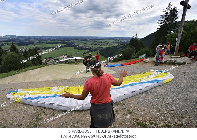 Pupils of a paragliding school prepare for their examination flight on Buchenberg mountain near Buching, Germany, 30 July 2017