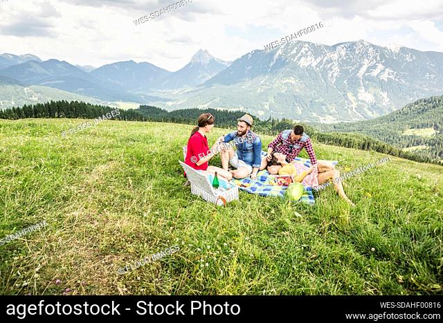 Friends having a picnic on a meadow in the mountains, Achenkirch, Austria