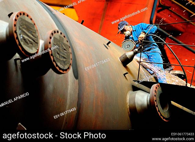Metal worker making a chamfer with the wheel for a weld on top of a piece