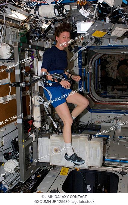 NASA astronaut Catherine (Cady) Coleman, Expedition 26 flight engineer, exercises on the Cycle Ergometer with Vibration Isolation System (CEVIS) in the Destiny...