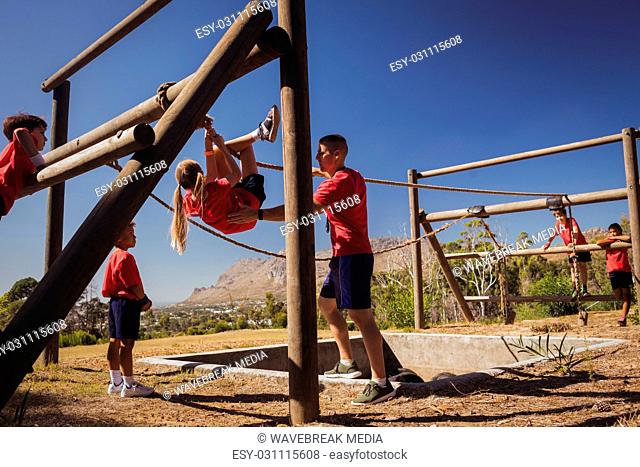 Trainer assisting a girl in obstacle course training