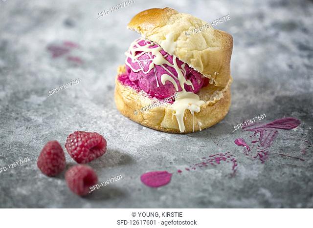 Beetroot Ice Cream in a sweet roll on a rustic metal surface decorated with Raspberries