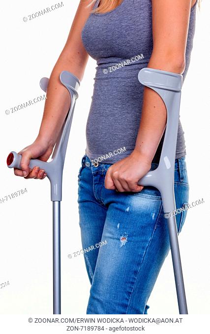 Eine junge Frau mit Krücken. Symbolfoto für Unfälle, Haushaltsunfälle und Versicherung