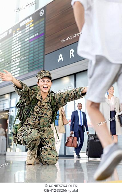 Son running greeting mother soldier at airport