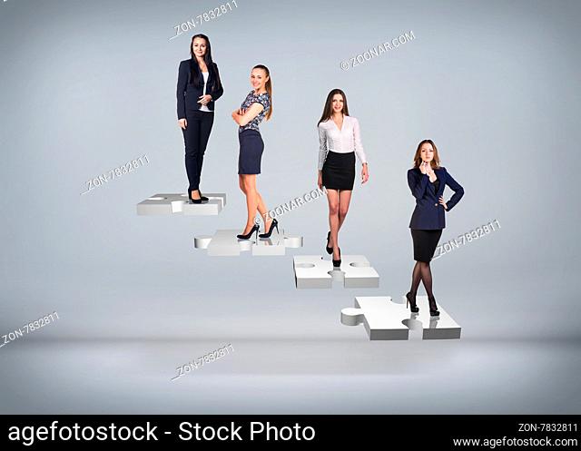 Business people stand on puzzle stairs on the gray background