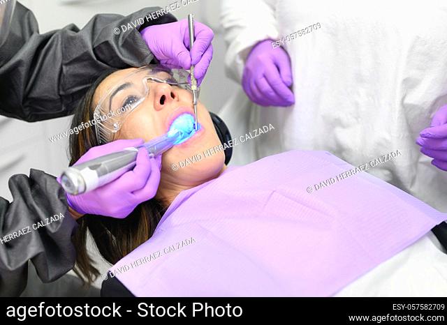 Young woman receiving ultraviolet light procedure at dentist office. High quality photo