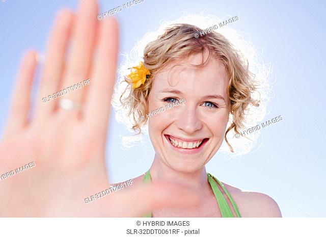 Smiling woman holding up hand