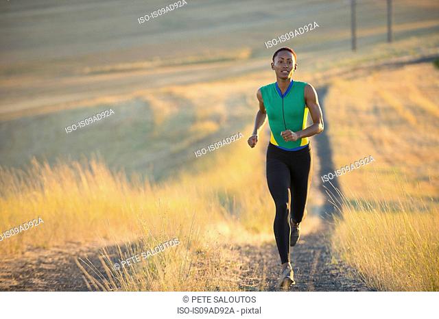Young woman running on dirt track, Bainbridge Island, Washington State, USA